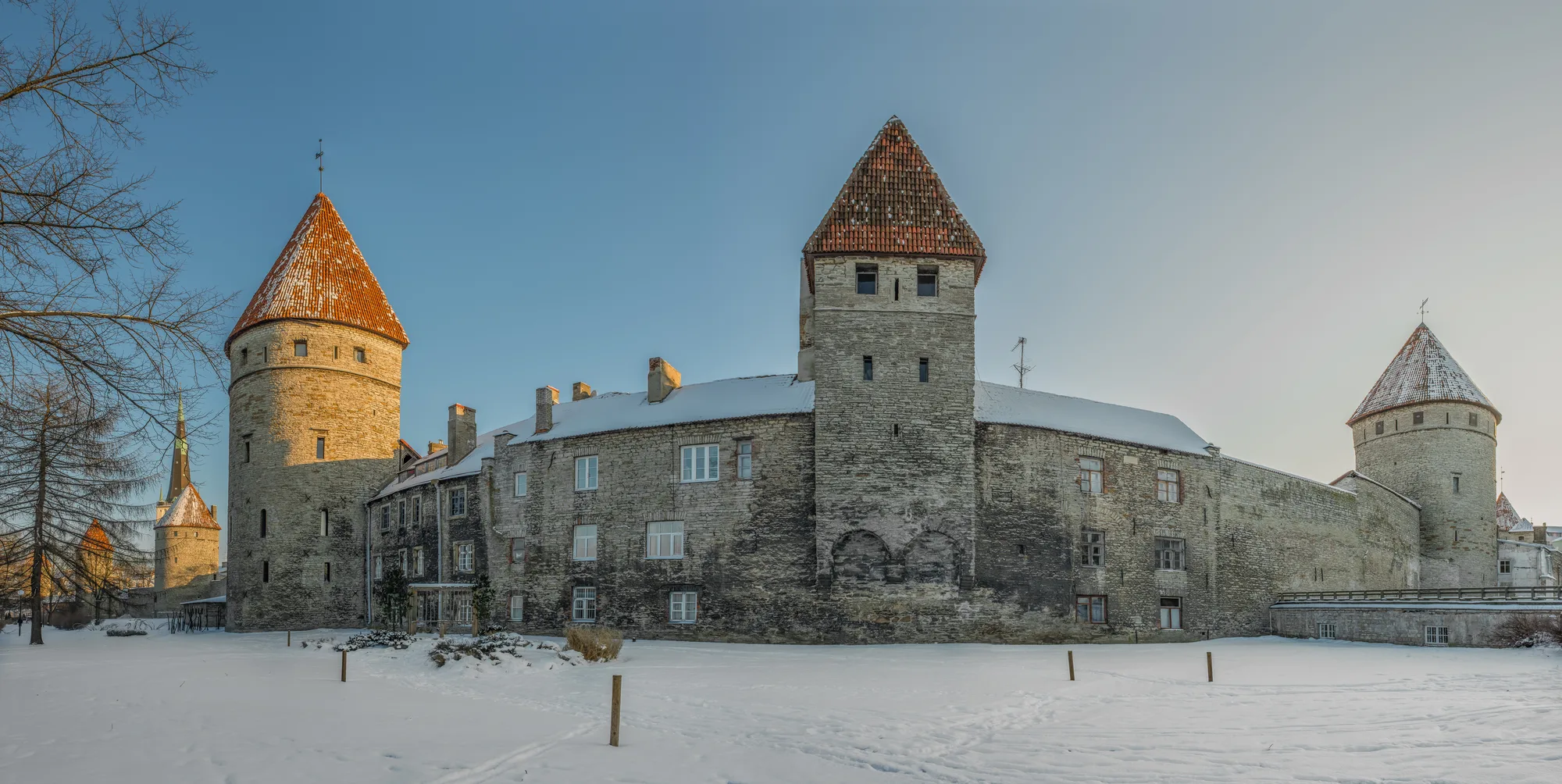 A stretch of Tallinn's medieval city wall at Tornide väljak (Towers' Square) with several red-roofed conical defensive towers