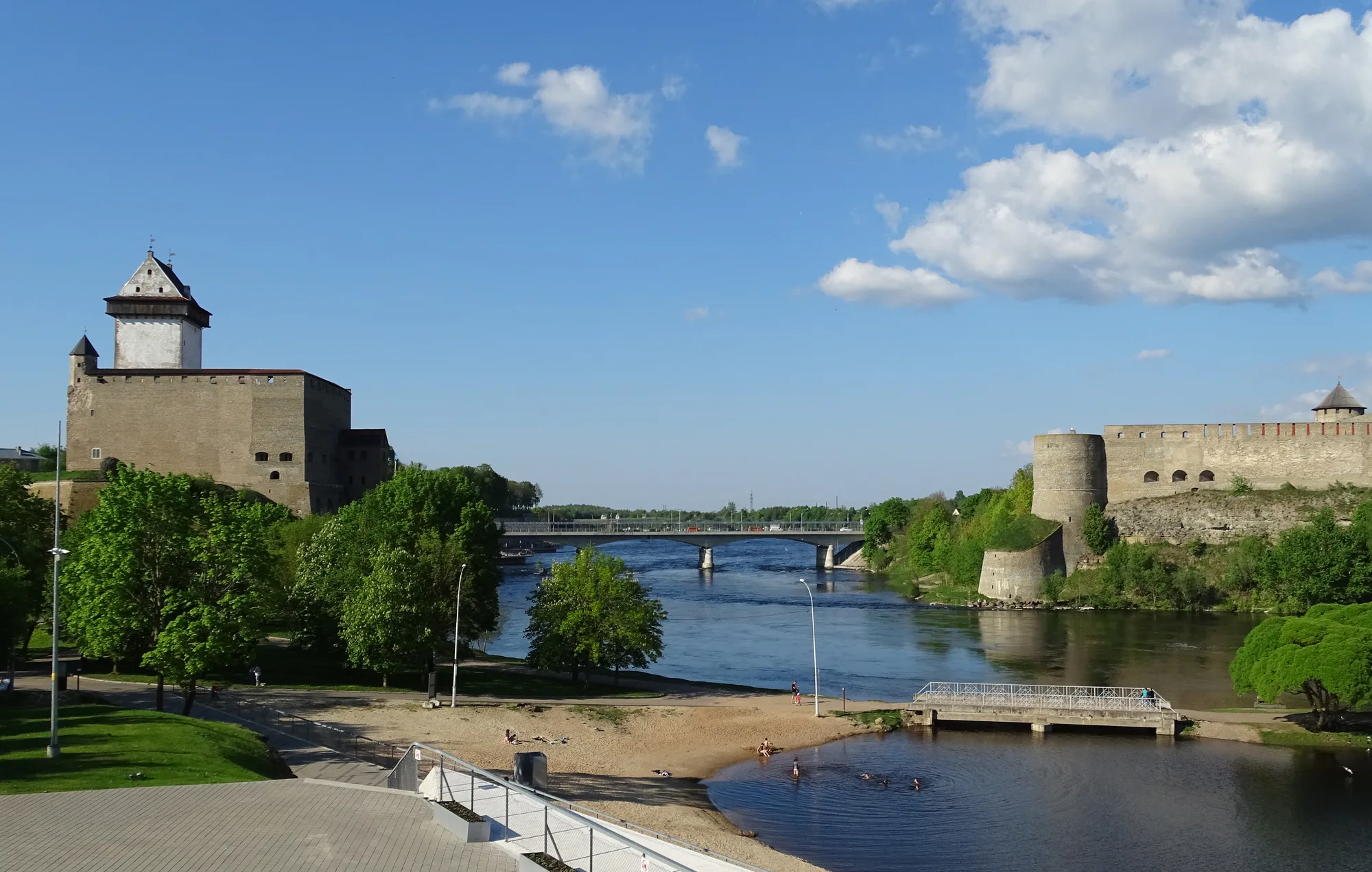 Narva Hermann Castle with its tall white tower on the Estonian bank of the Narva River, facing Ivangorod Fortress across the water