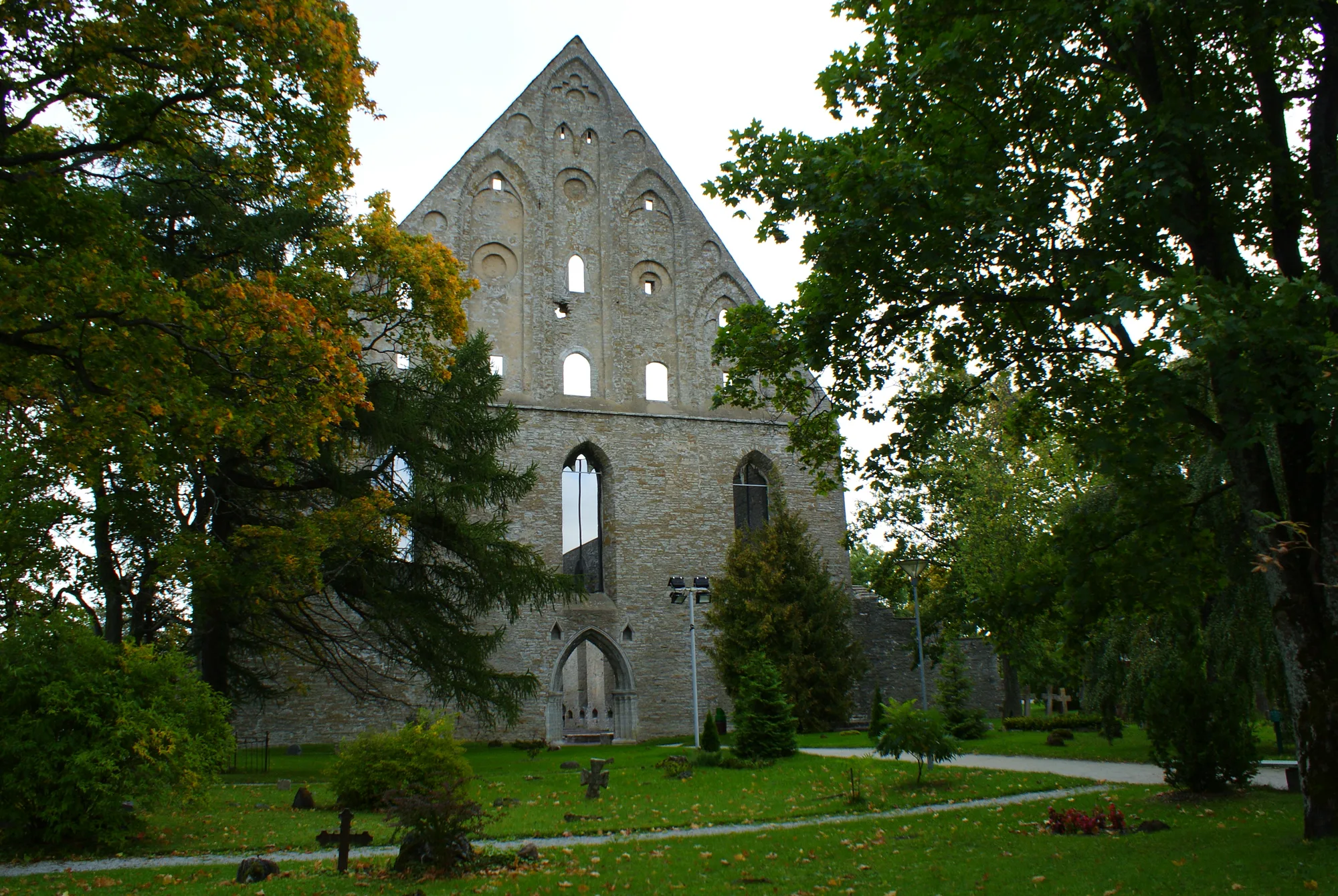 The ruined tall west gable and pointed-arch windows of St Bridget's (Pirita) Convent in Tallinn, with the grounds in front