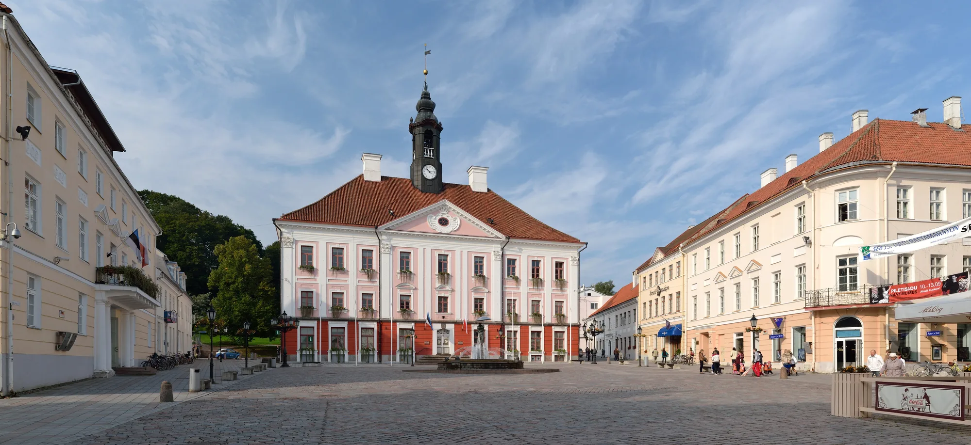 Tartu Town Hall Square in summer with the pink Town Hall, clock tower and the Kissing Students fountain, Estonia